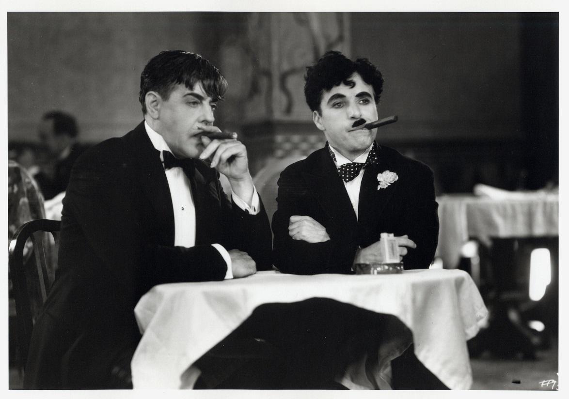 Чарли Чаплин курит сигару